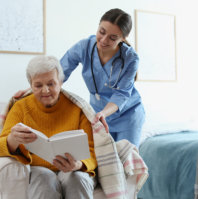 caregiver giving senior blanket