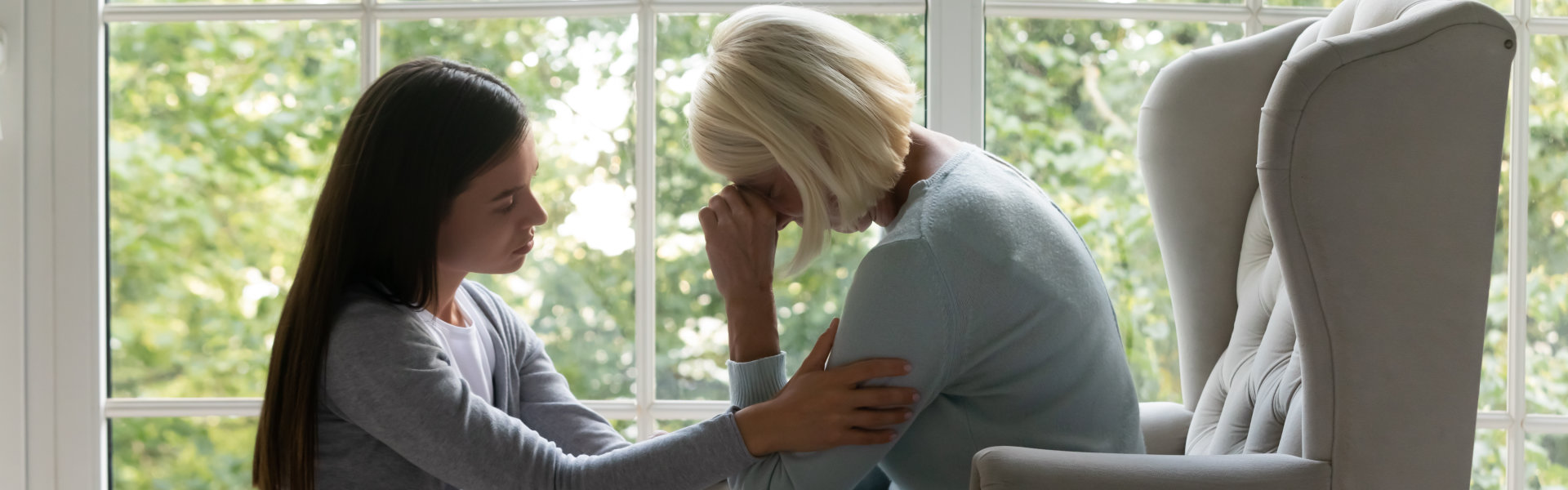 young woman comforting senior